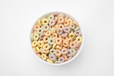 Photo of Tasty cereal rings in bowl on white table, top view