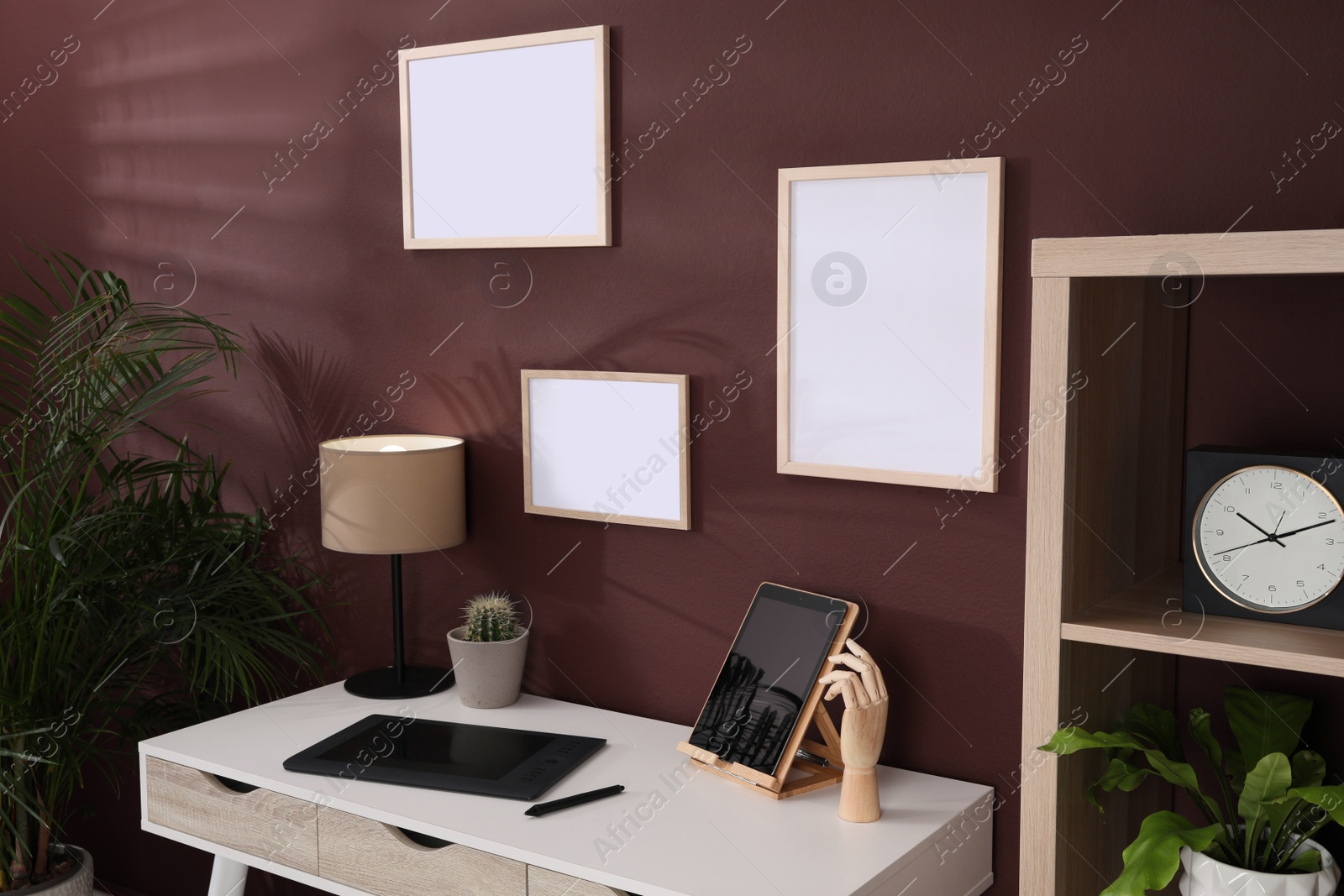 Photo of Empty frames hanging on brown wall indoors. Mockup for design