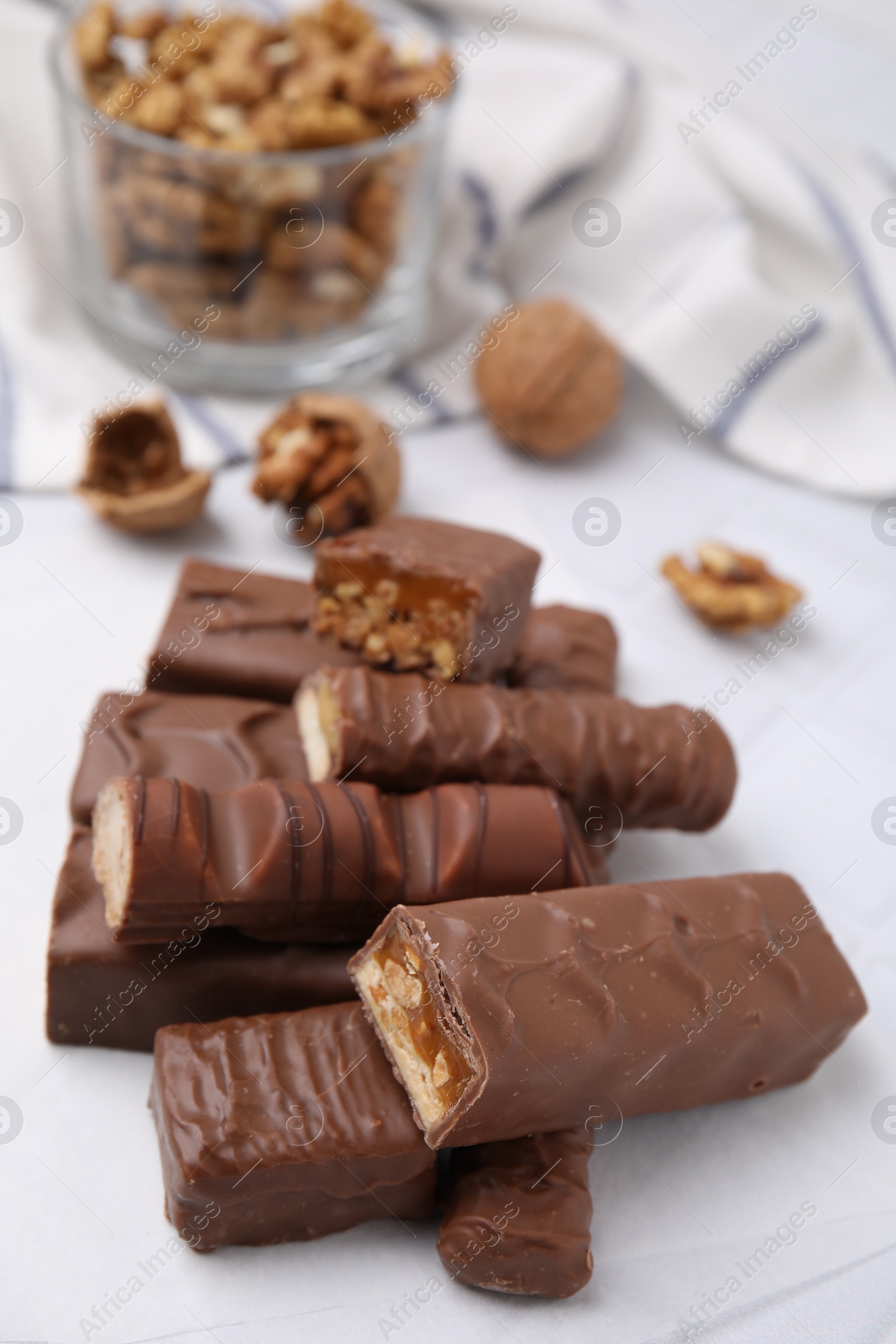 Photo of Pieces of different tasty chocolate bars on white table
