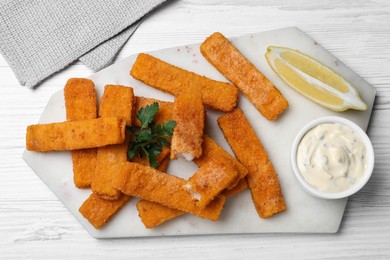 Tasty fresh fish fingers served on white wooden table, flat lay