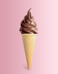 Delicious soft serve chocolate ice cream in crispy cone on pastel pink background