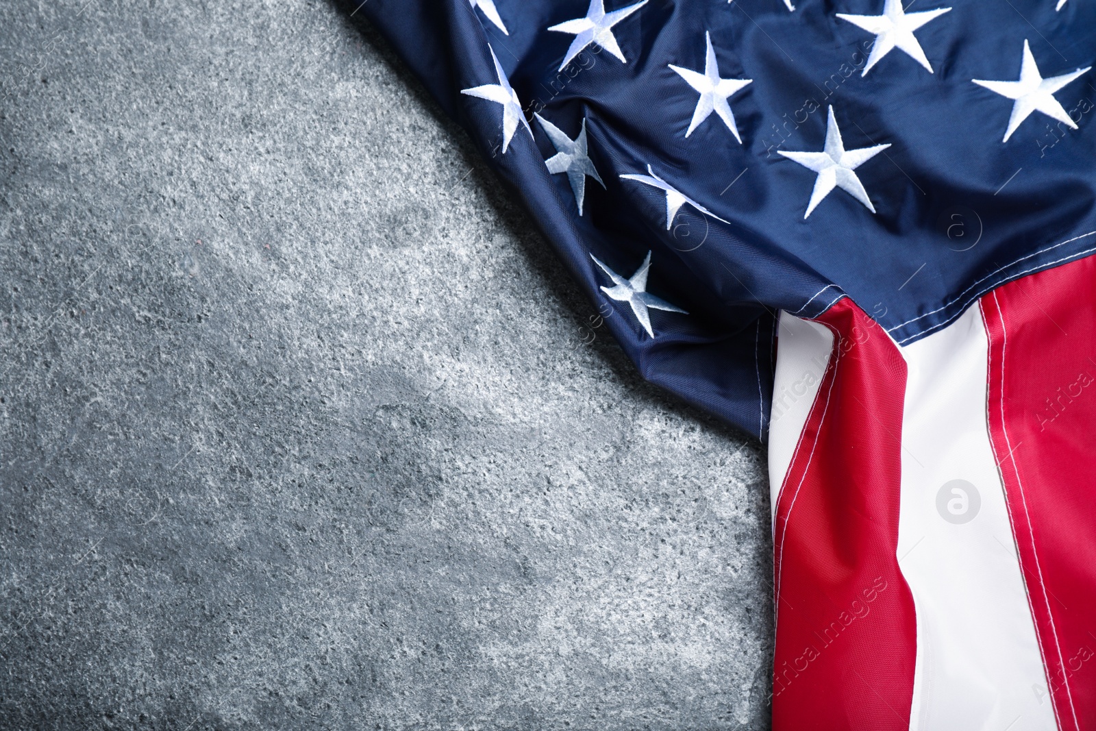 Photo of National flag of America on grey table, top view. Space for text