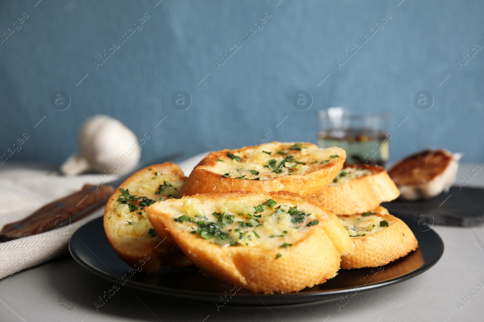 Photo of Plate with delicious homemade garlic bread on table, closeup. Space for text