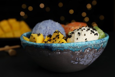 Photo of Delicious poke bowl on table against blurred lights, closeup