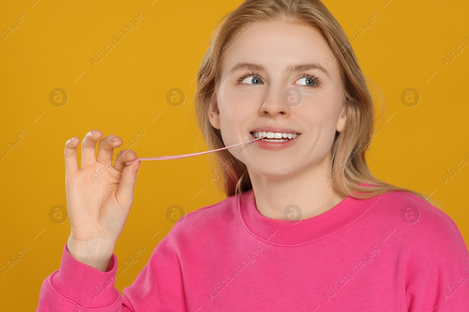 Photo of Happy young woman with bubble gum on yellow background