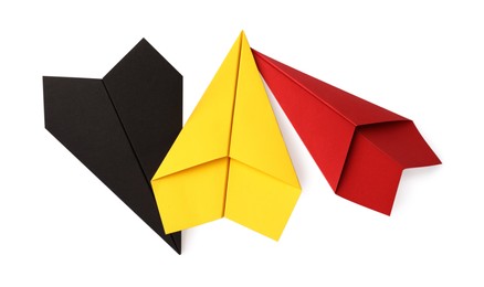 Photo of Handmade black, yellow and red paper planes isolated on white, top view