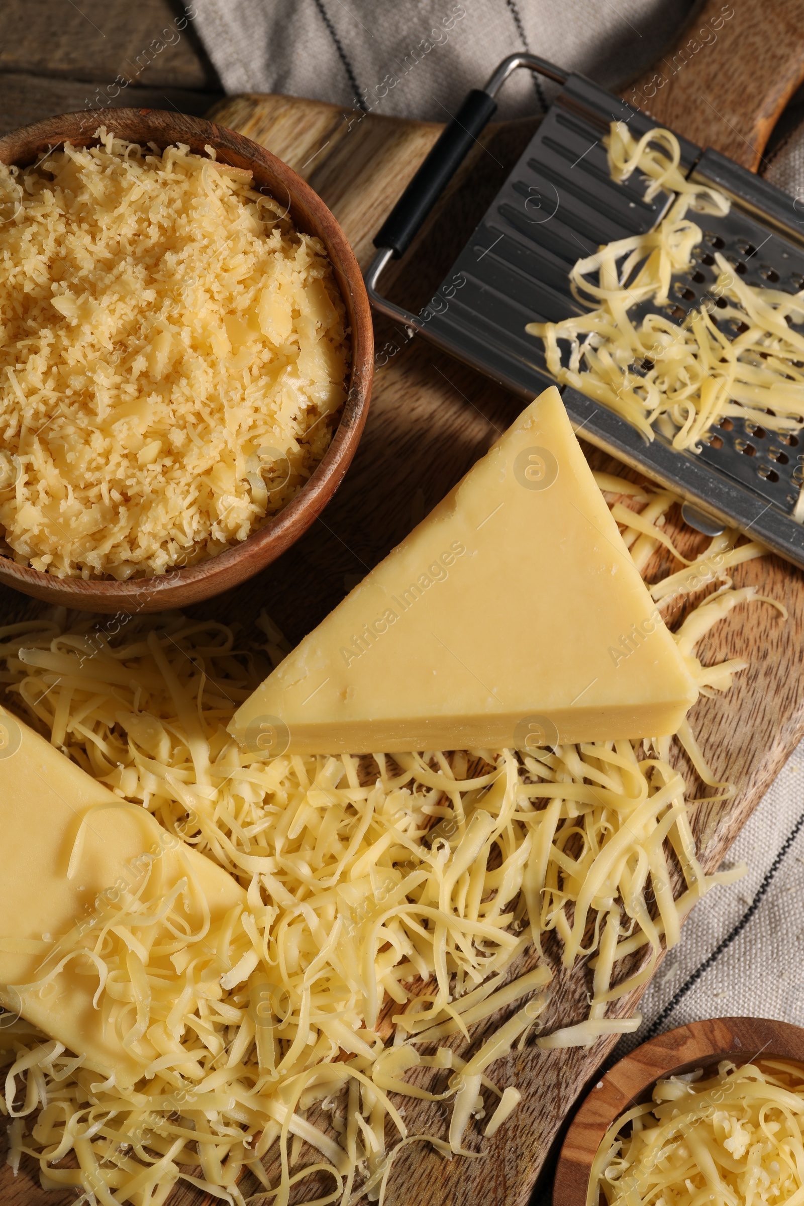 Photo of Grated and whole pieces of cheese on table, top view