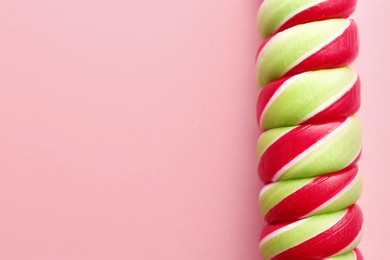 Photo of Sweet colorful lollipop on pink background, top view. Space for text