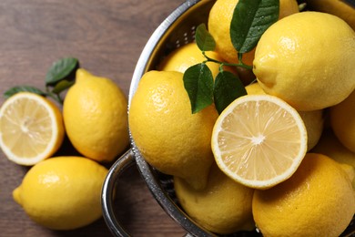 Photo of Fresh lemons and green leaves on table, top view