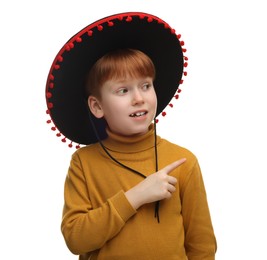 Photo of Cute boy in Mexican sombrero hat pointing at something on white background