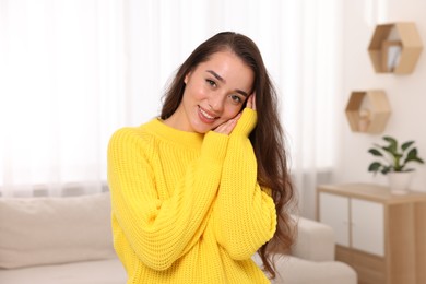 Photo of Beautiful young woman in stylish warm sweater at home