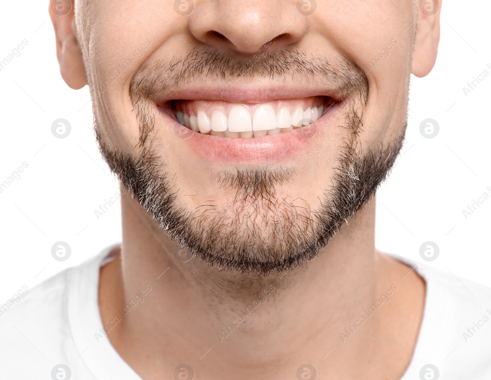 Photo of Young man with beautiful smile on white background. Teeth whitening