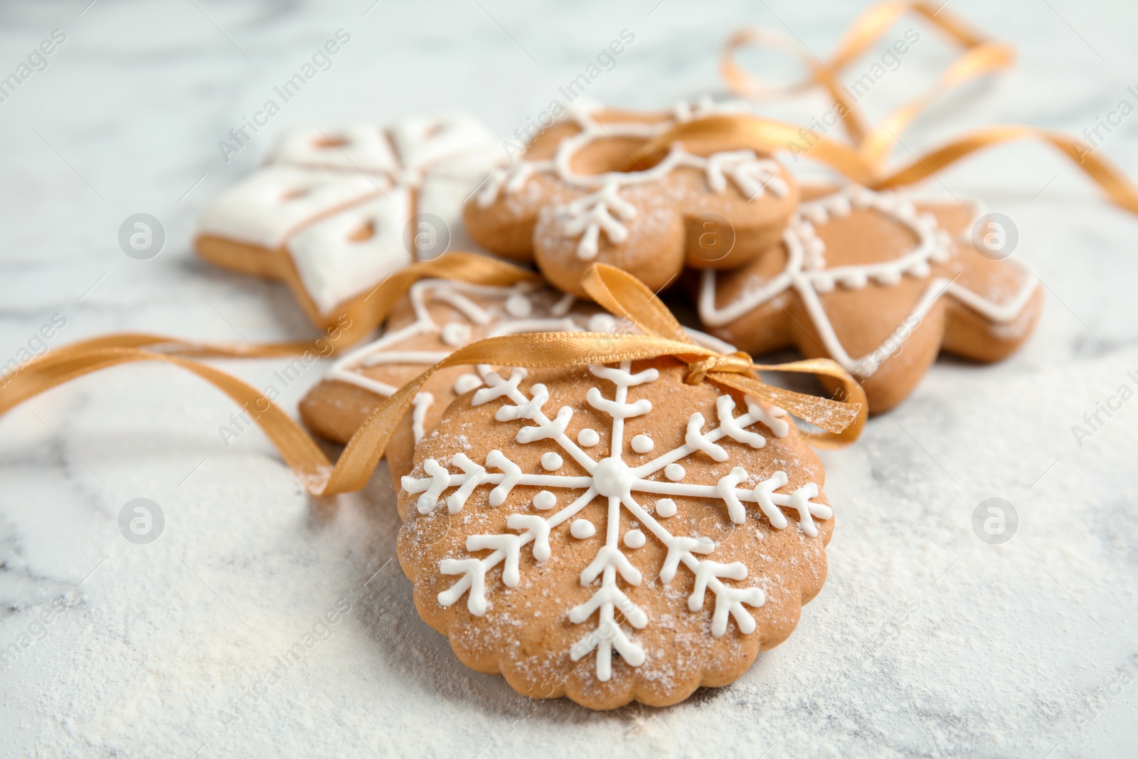 Photo of Tasty decorated Christmas cookies with ribbon on table