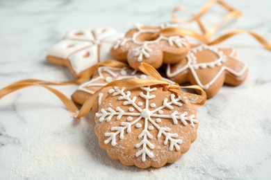 Tasty decorated Christmas cookies with ribbon on table