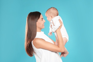 Portrait of happy mother with her baby on color background