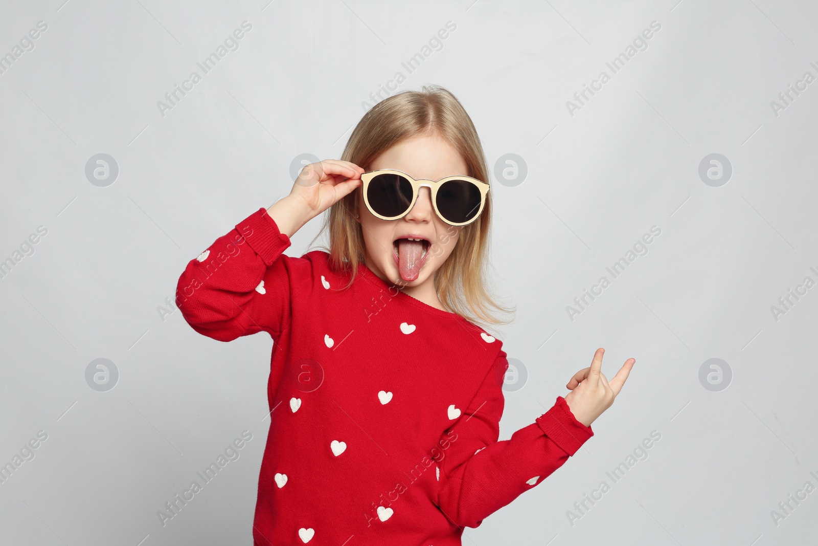 Photo of Portrait of cute funny little girl on light grey background