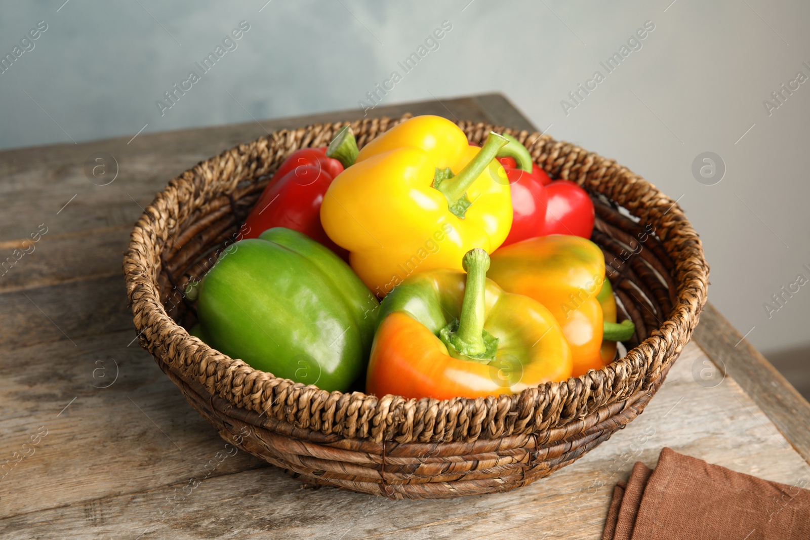 Photo of Bowl with ripe paprika peppers on wooden table