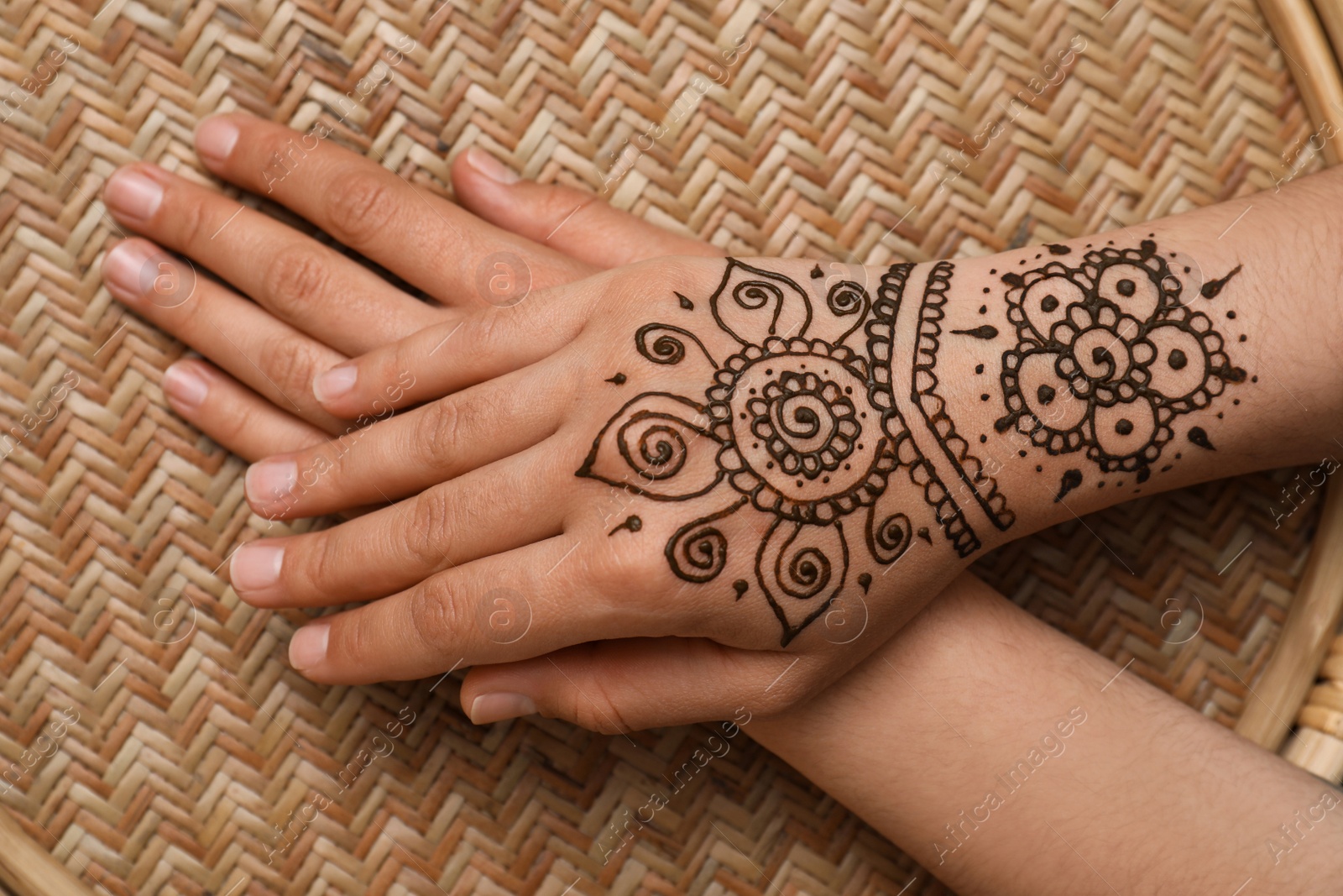 Photo of Woman with beautiful henna tattoo on hand, top view. Traditional mehndi