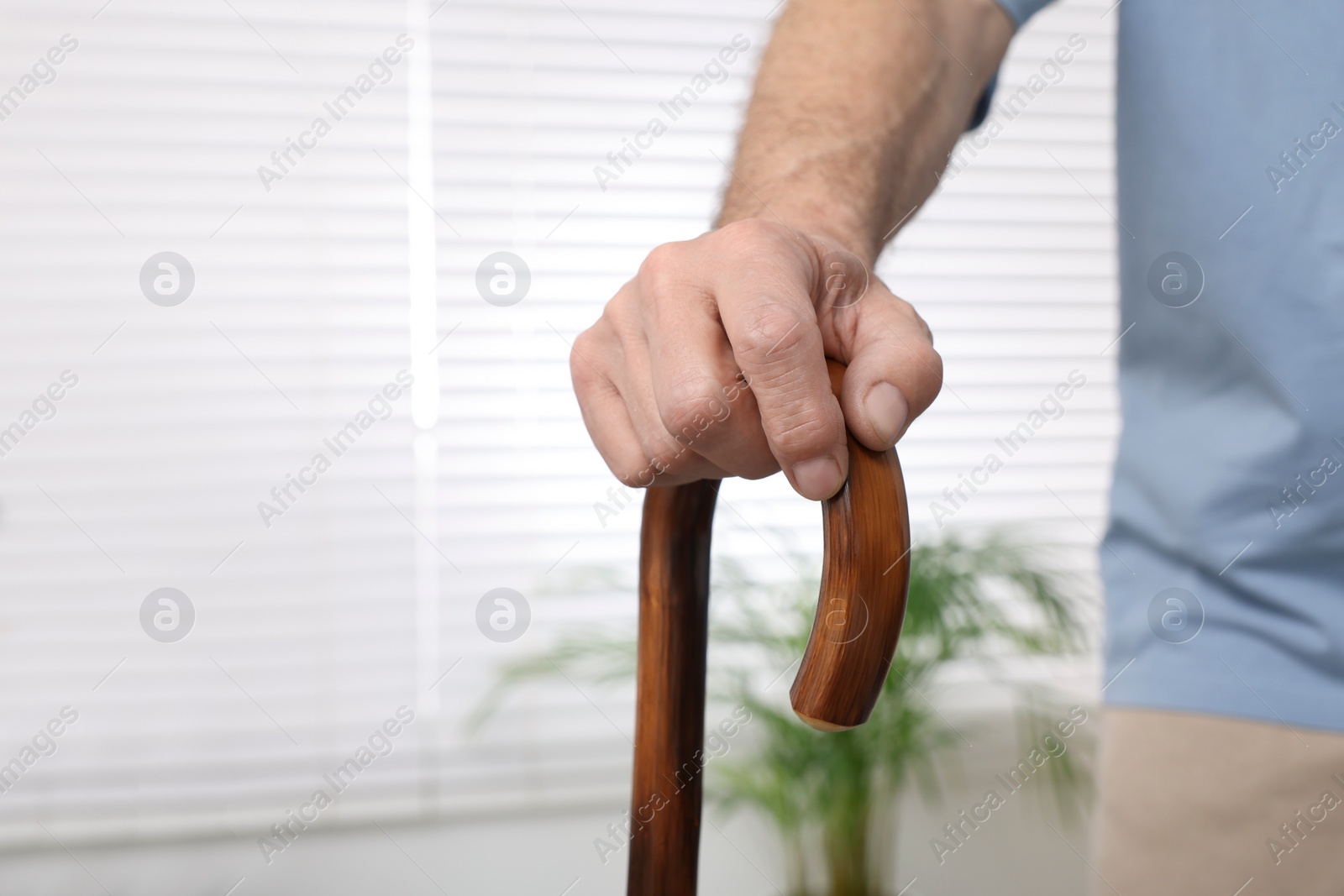 Photo of Senior man with walking cane at home, closeup. Space for text