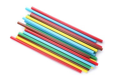 Many colorful glue sticks on white background, top view