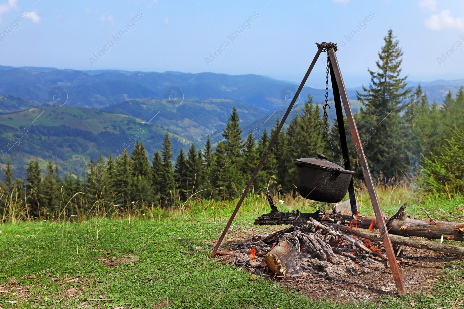 Photo of Cooking breakfast on fire in mountains. Camping season