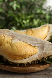 Photo of Piecesfresh ripe durian fruit on wooden table, closeup