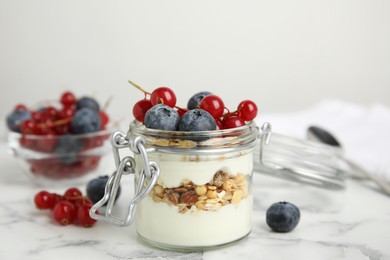 Photo of Delicious yogurt parfait with fresh berries on white marble table, closeup