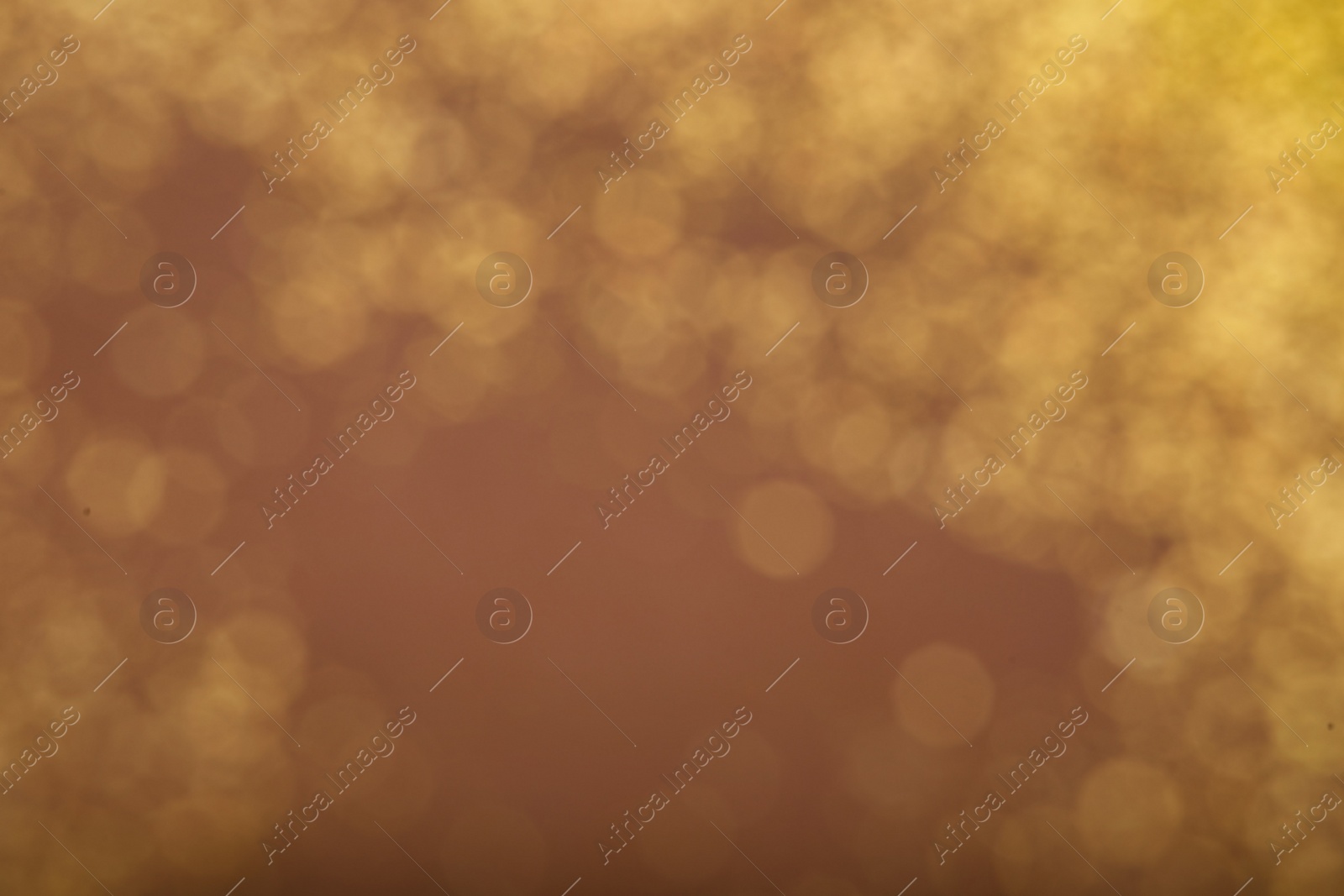 Photo of Blurred view of golden lights on dusty rose background. Bokeh effect