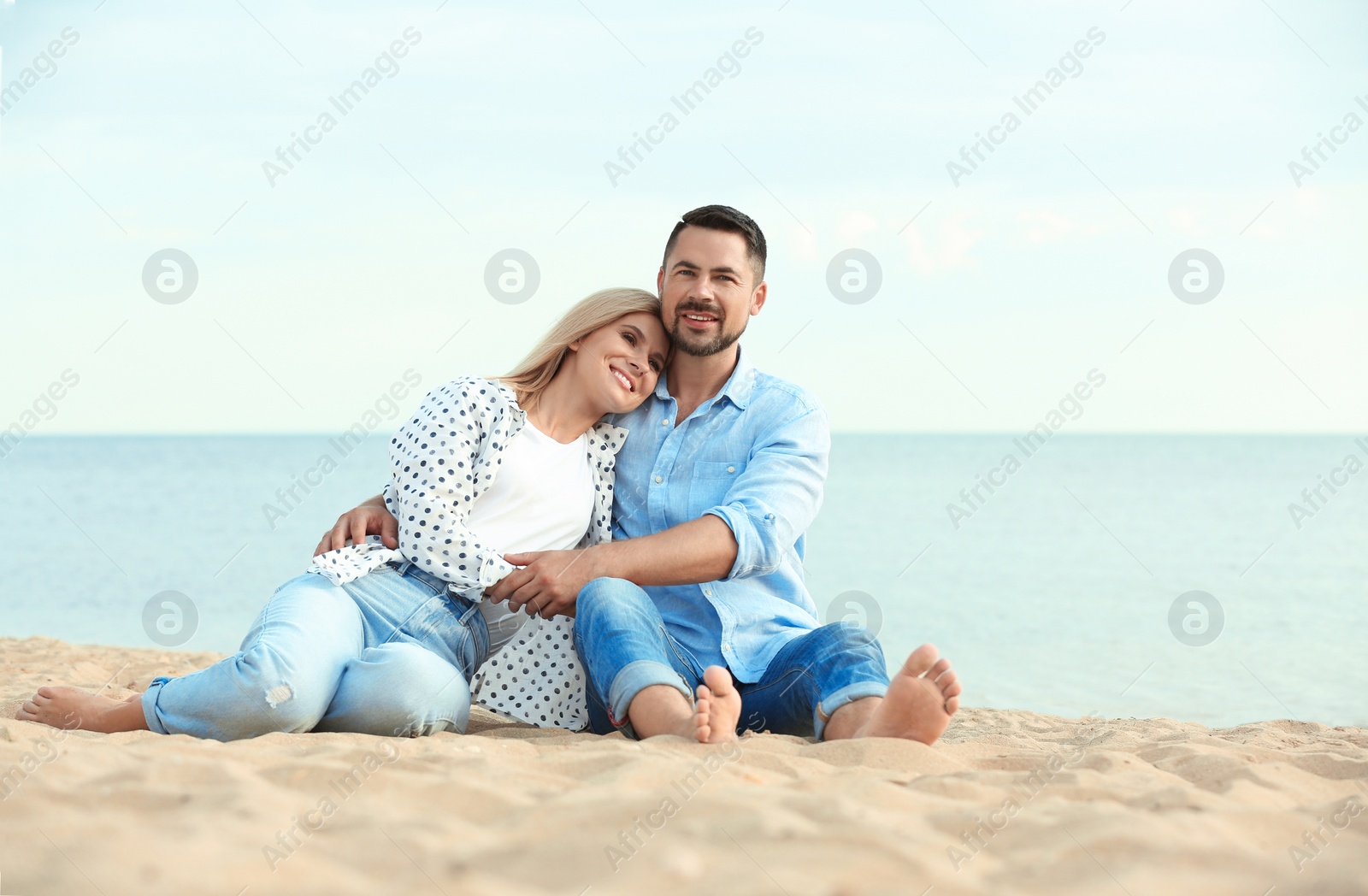 Photo of Happy romantic couple spending time together on beach, space for text