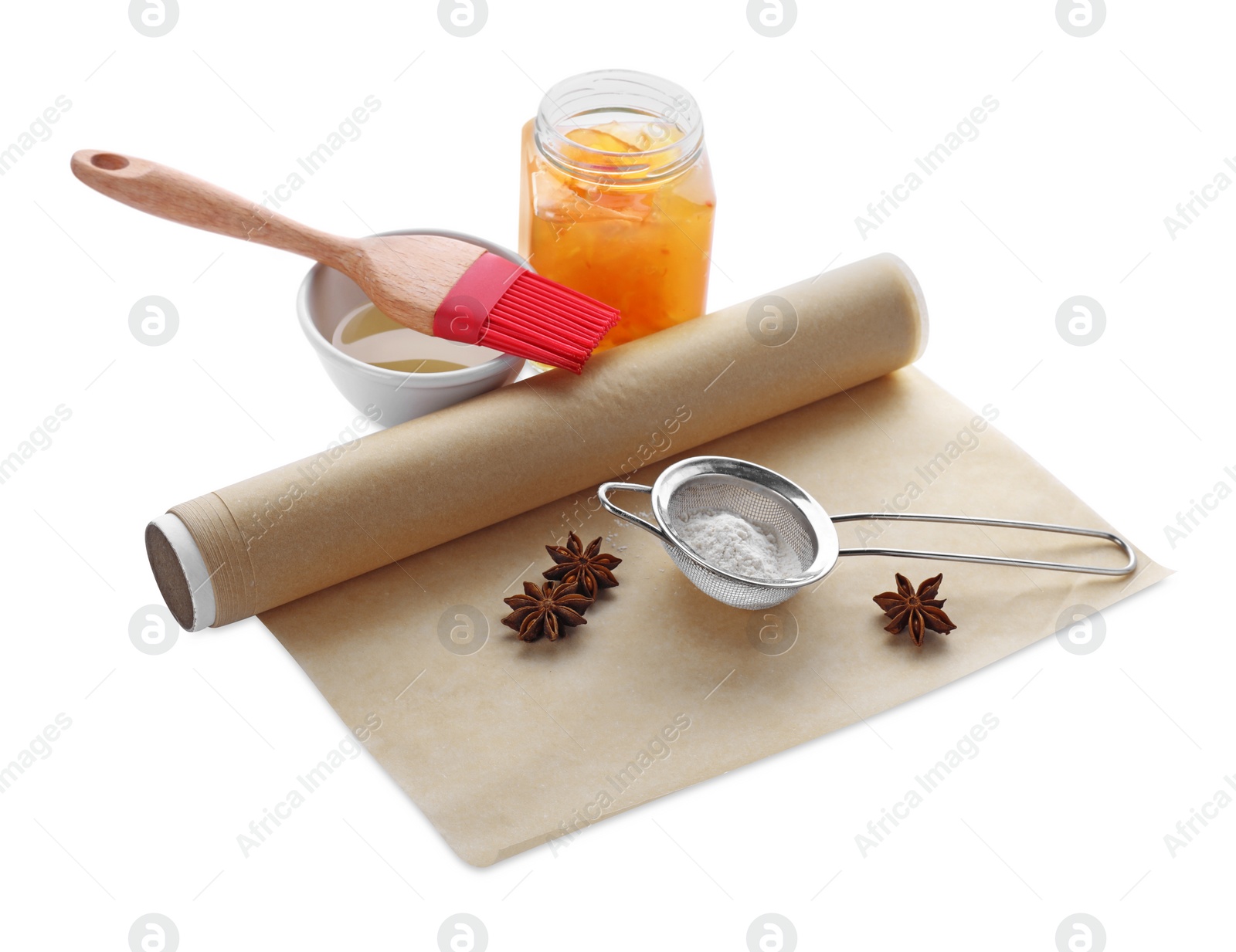 Photo of Roll of baking parchment paper and different ingredients isolated on white