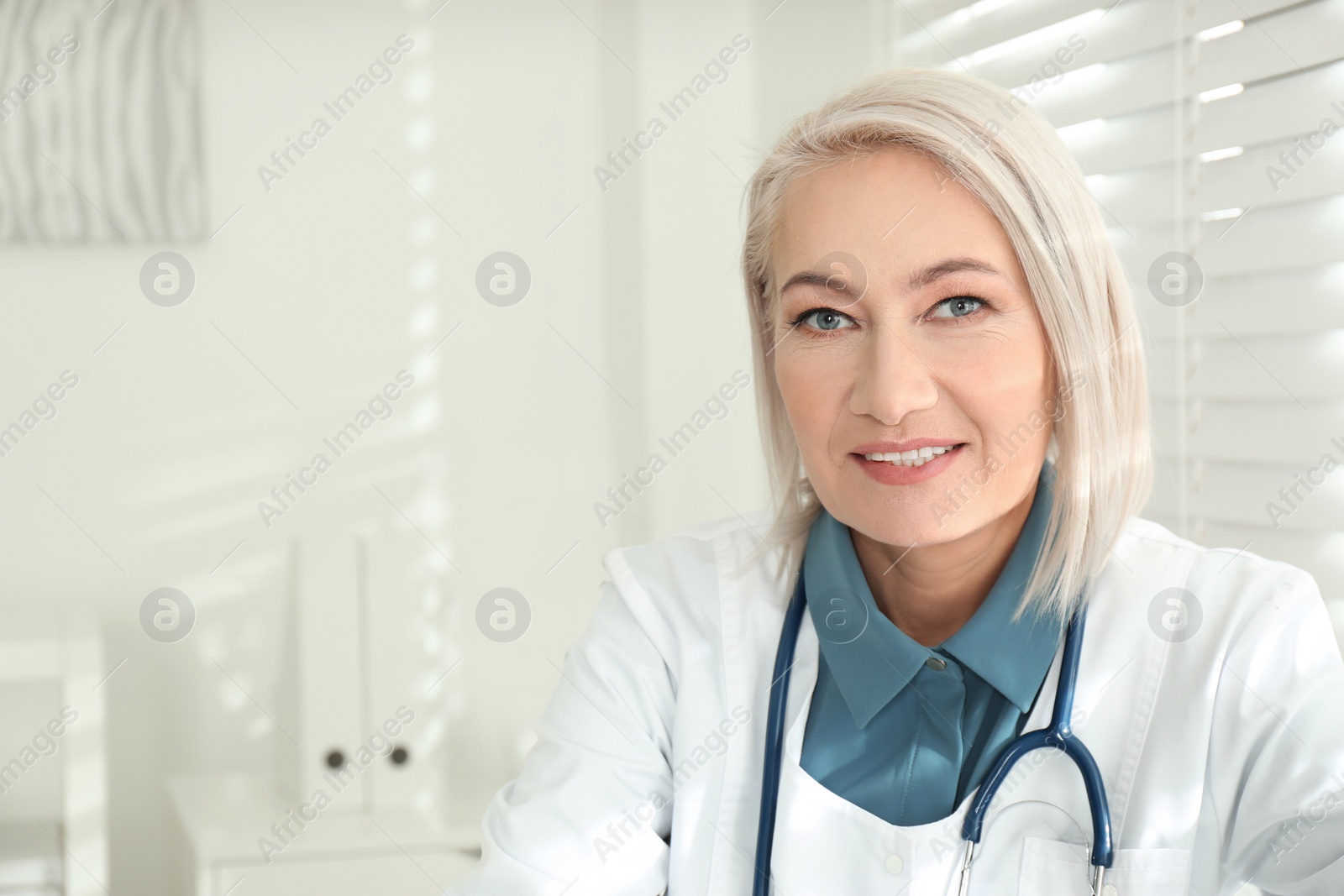 Photo of Portrait of mature female doctor in white coat at workplace