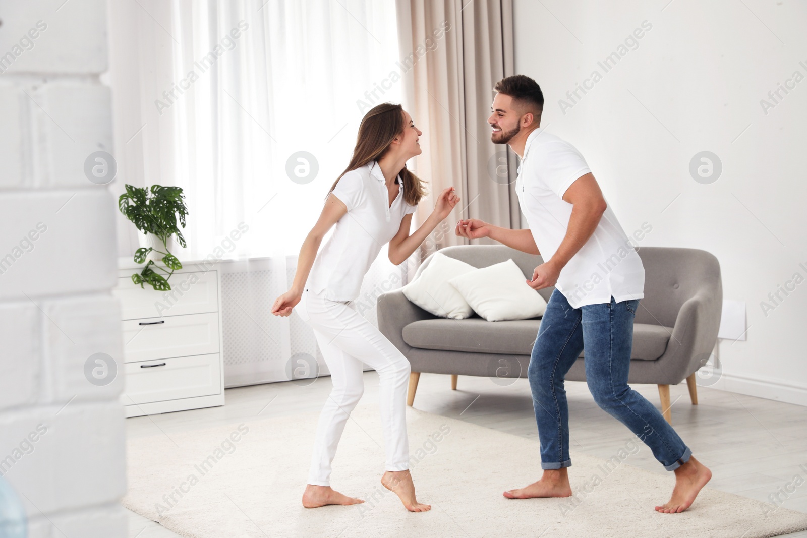 Photo of Lovely young couple dancing together at home