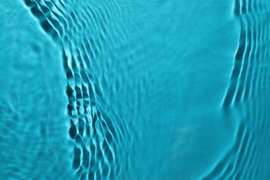 Rippled surface of clear water on light blue background, top view