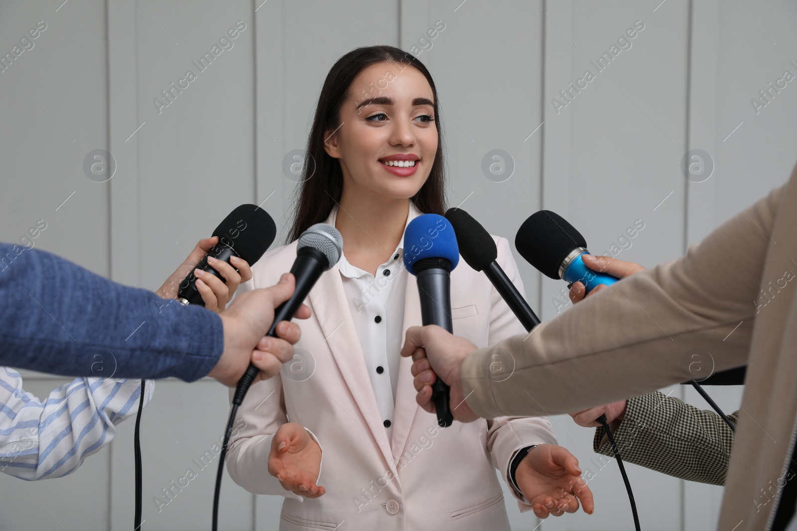 Photo of Happy business woman giving interview to journalists at official event