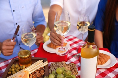 Photo of Young people having picnic at table, closeup