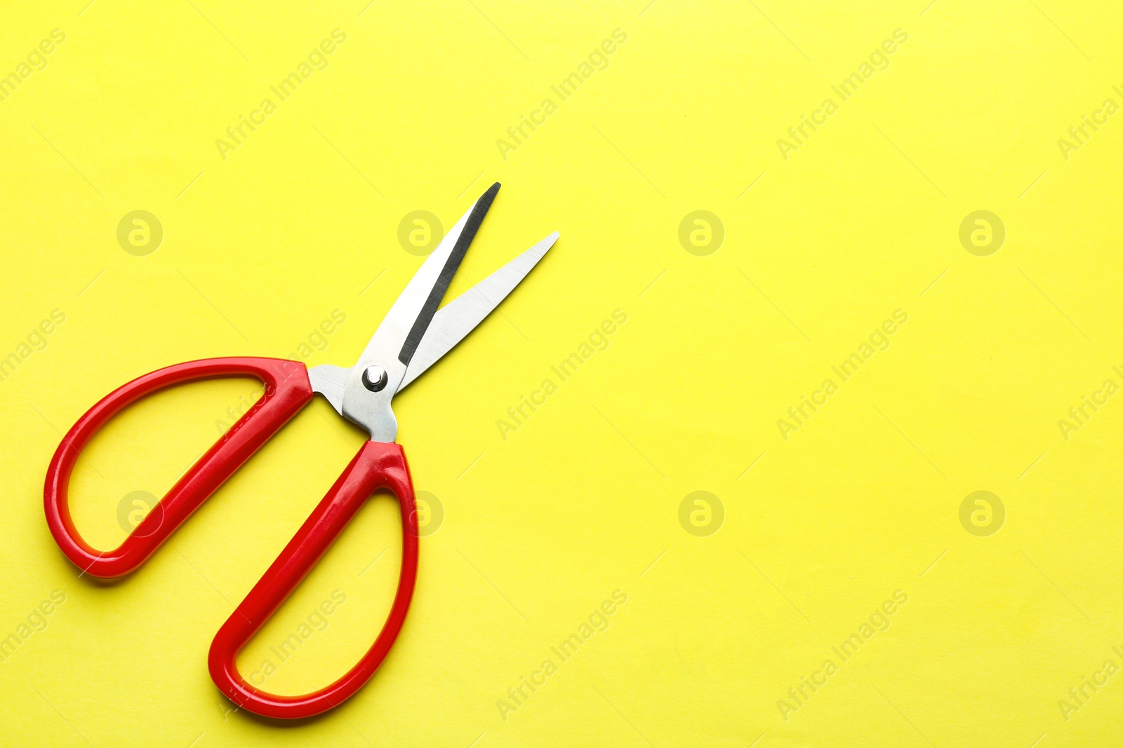 Photo of Pair of sharp scissors on color background, top view. Space for text
