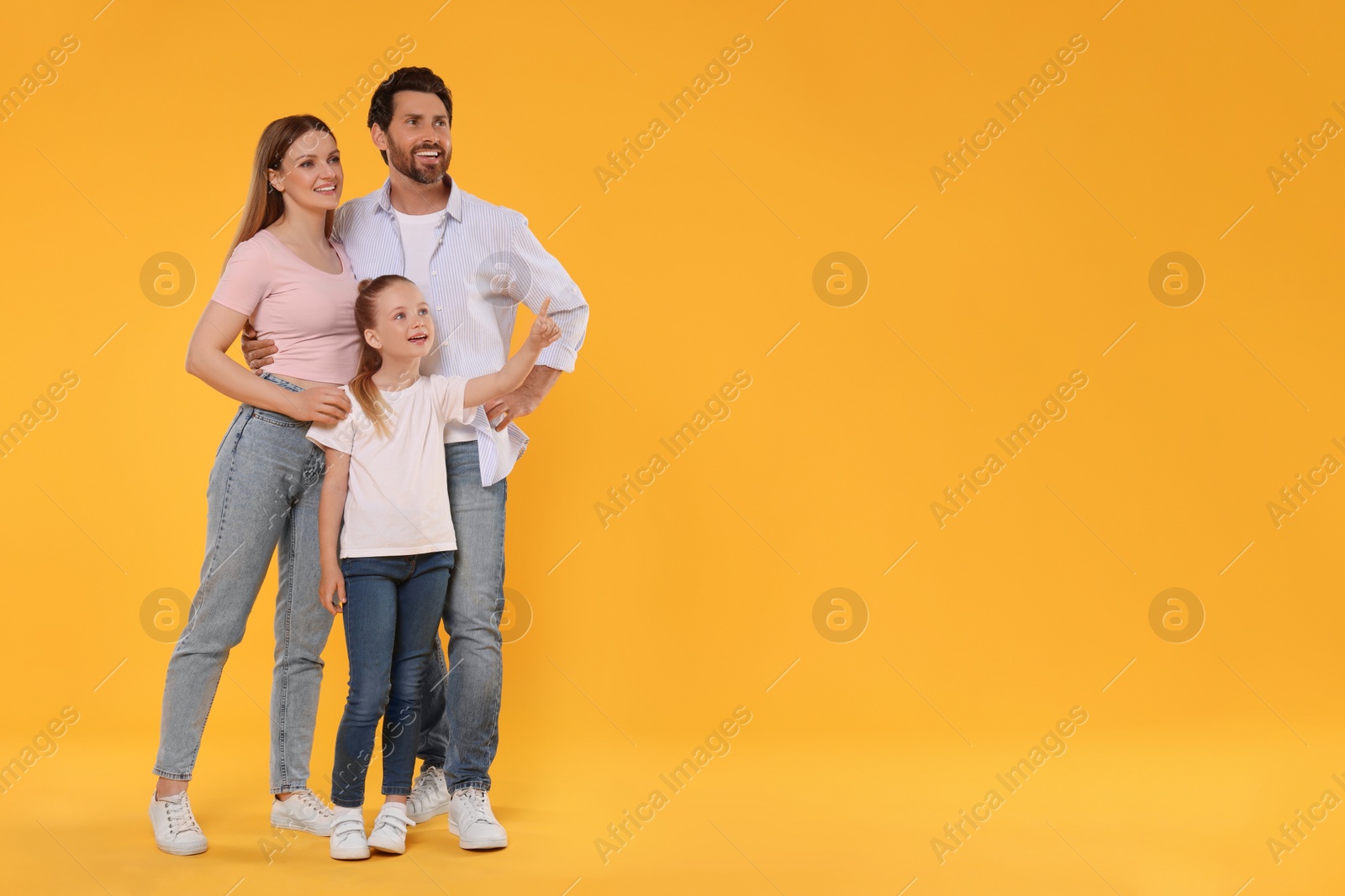 Photo of Happy family on orange background, space for text