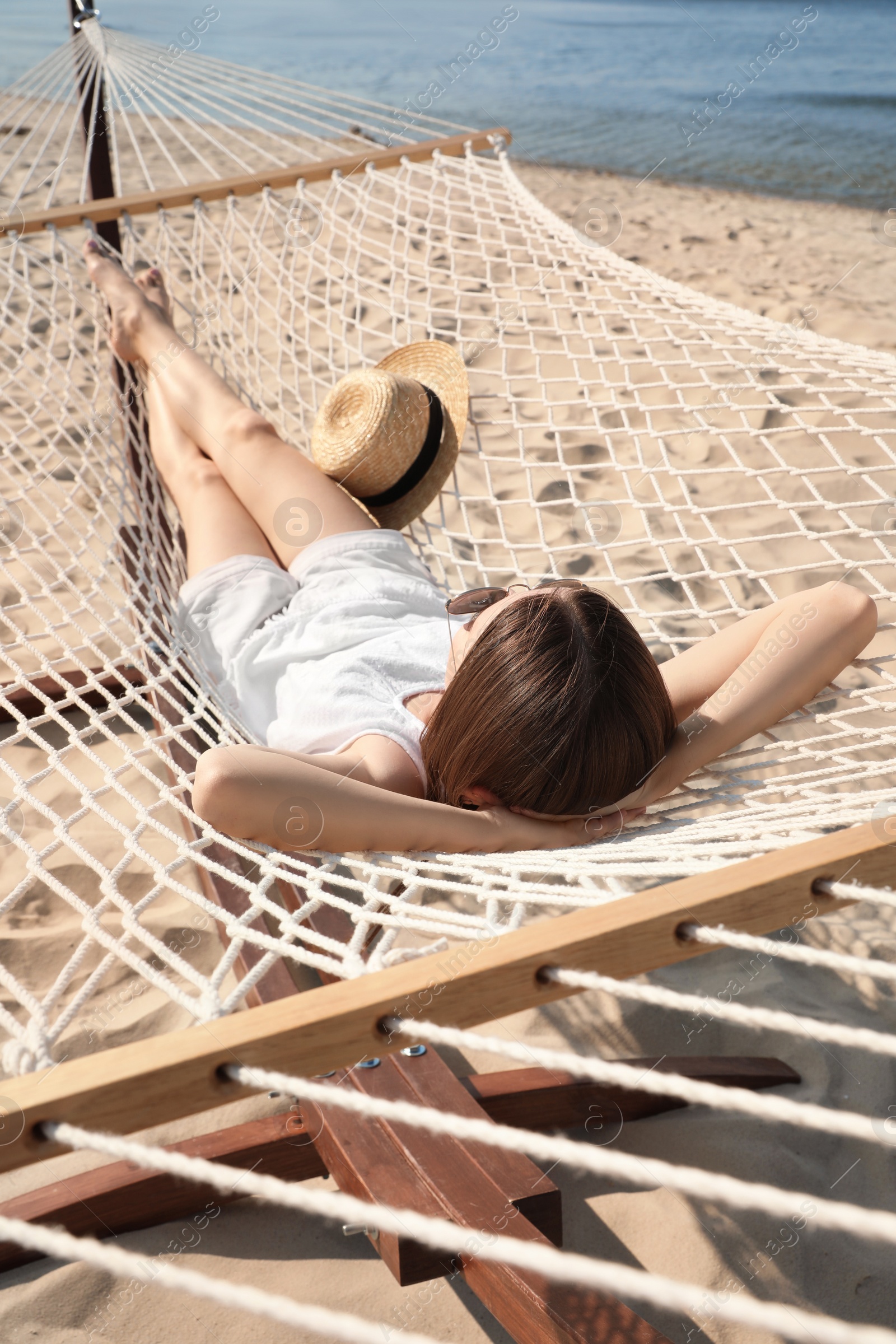 Photo of Young woman relaxing in hammock on beach