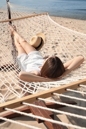 Young woman relaxing in hammock on beach