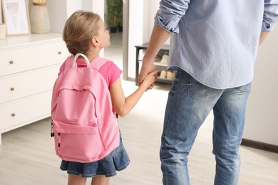 Photo of Little girl with father at home. Ready to go to school