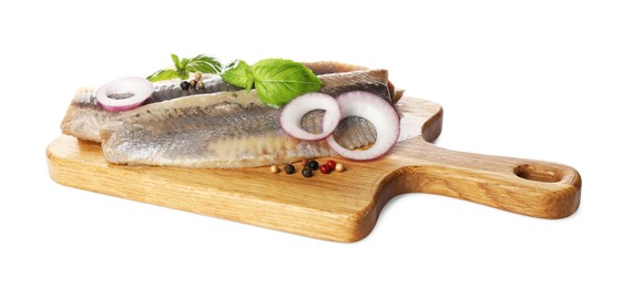 Wooden board with delicious salted herring fillets, onion rings, peppercorns and basil isolated on white