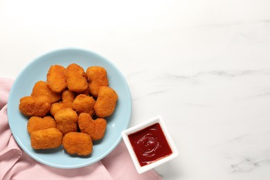 Tasty ketchup and chicken nuggets on marble table, flat lay. Space for text