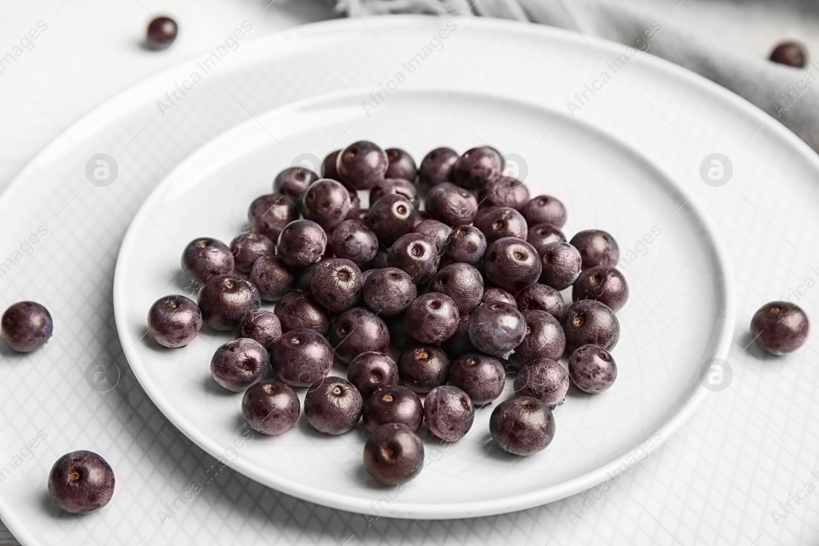 Photo of Plates with fresh acai berries on table, closeup