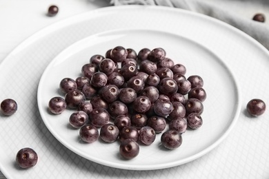 Plates with fresh acai berries on table, closeup