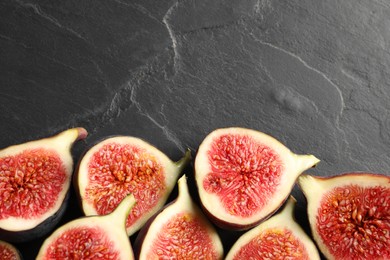 Photo of Halves of fresh ripe figs on grey textured table, flat lay. Space for text
