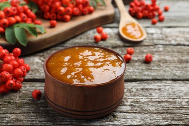 Photo of Delicious rowan jam in bowl on wooden table. Space for text