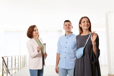 Real estate agent showing new apartment to young couple