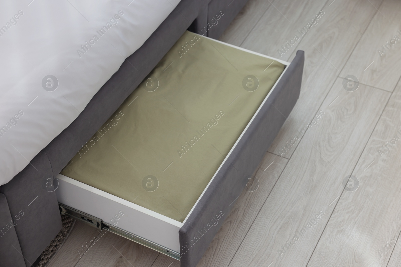 Photo of Storage drawer with bedding under comfortable bed in room