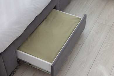 Photo of Storage drawer with bedding under comfortable bed in room