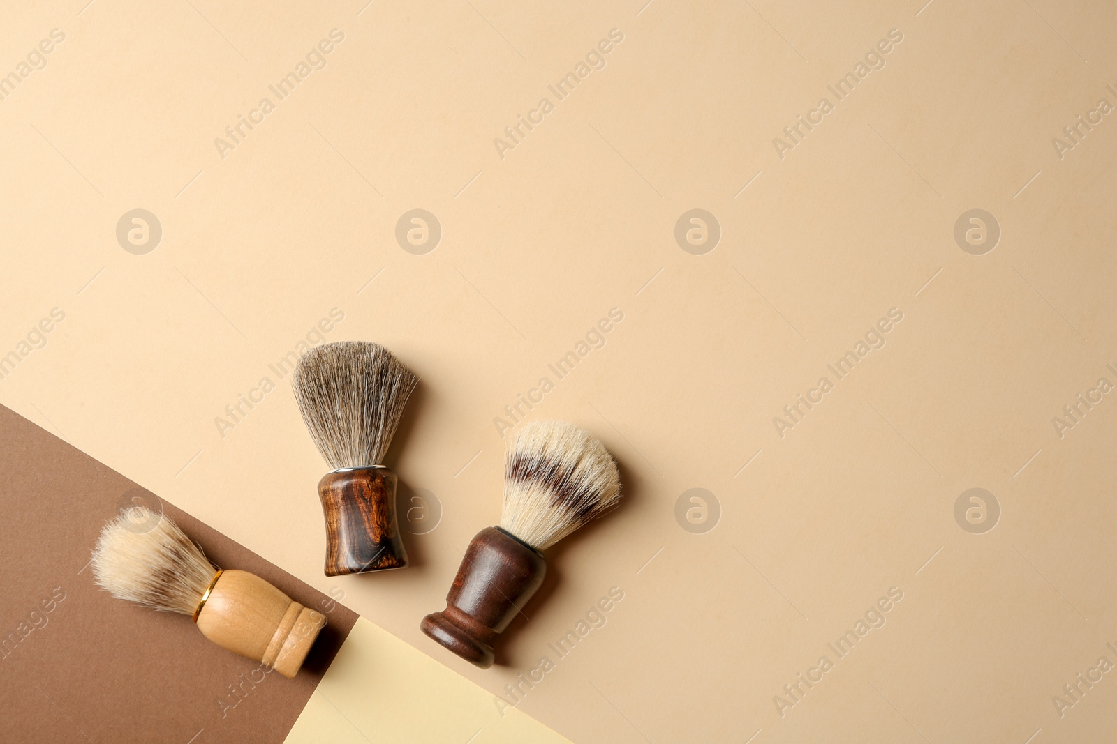 Photo of Flat lay composition with men's shaving brushes and space for text on color background